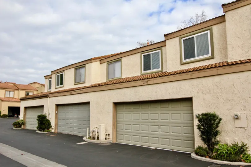 A two story apartment building in Mark III Townhomes with garages and a terra cotta roof,