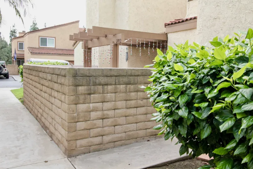Stone fence in Mark III Townhomes with Christmas lights on a cloudy day.