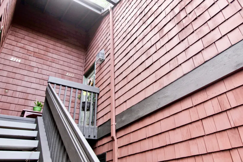 Staircase to a Quail Ridge apartment with red shingle sidlng.