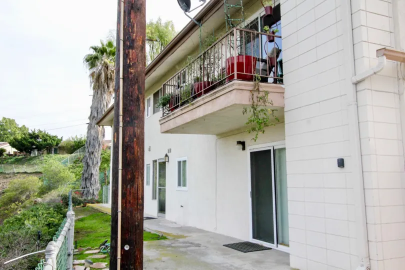 A two story white building with a gate and plants at shadow lane community in fullerton, california.
