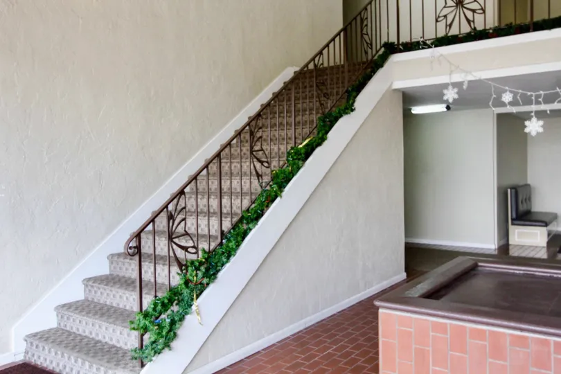 Shadow LAne staircase with Christmas garland and brick floor.