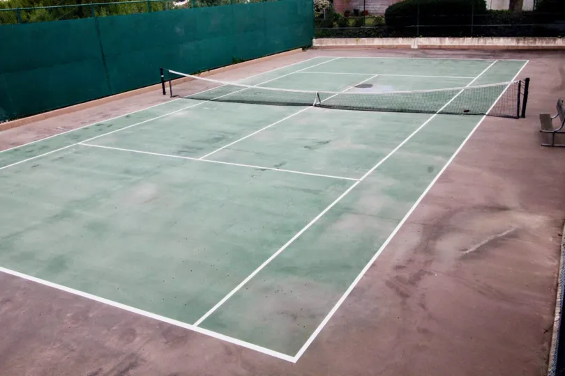 Tennis court is empty, there is no member in it with net and chairs