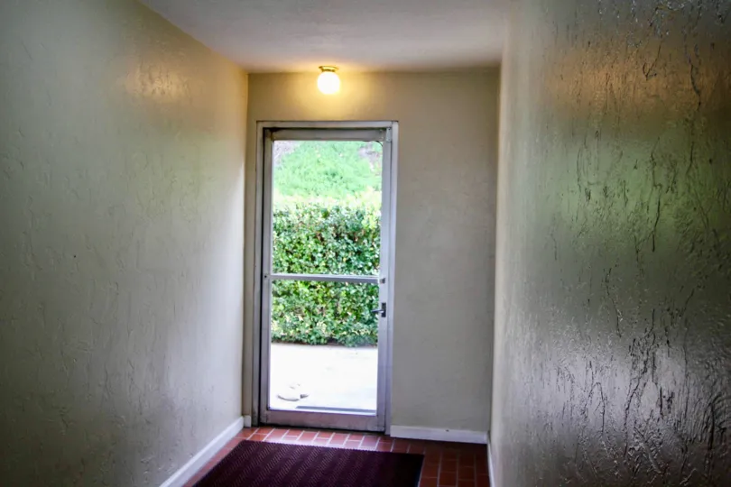 A glass door in the Shadow Lane community with trimmed bushes.