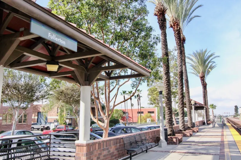 Soco Walk Fullerton California with short wall, roof and high grown trees arranged in order