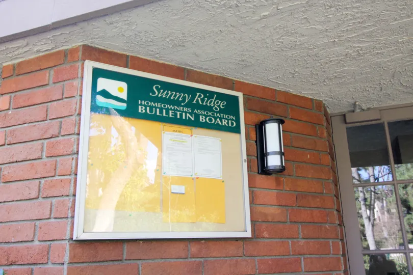 Bulletin board in Sunny Ridge Townhomes on a red brick wall.