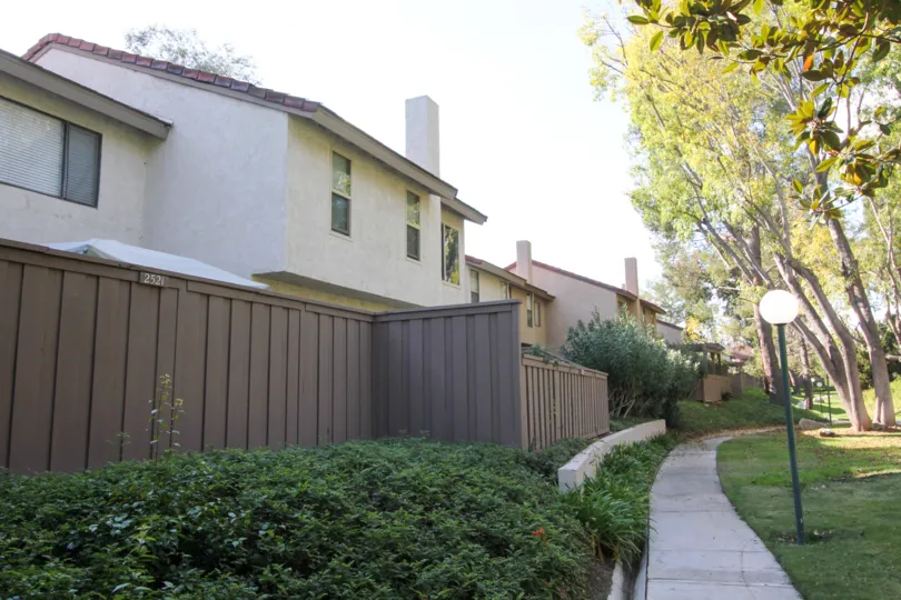 Sidewalk around the Sunny Ridge Townhomes with a fence and lamp posts.