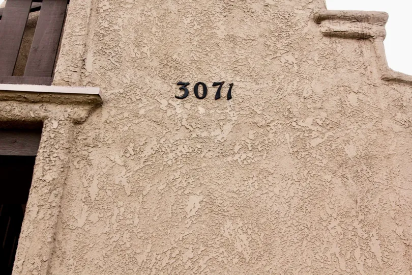 A tan wall close up number 3071 in the community Via Valencia.