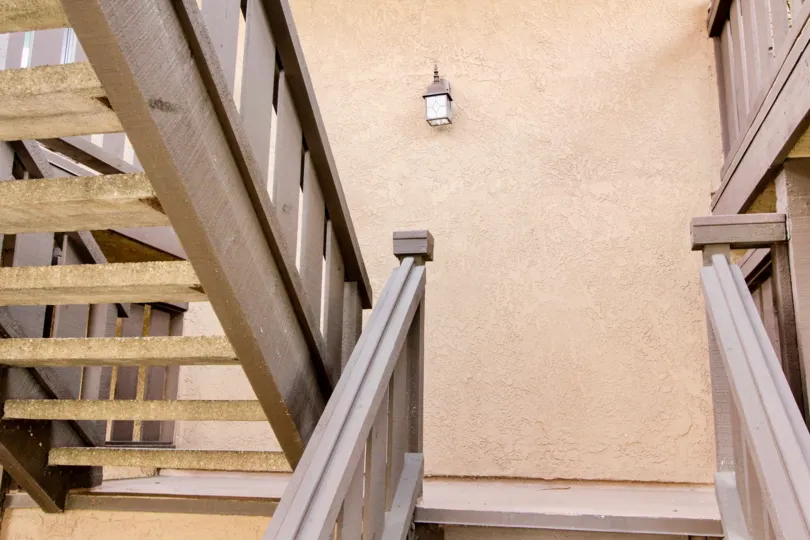 The stairs in villa at Via Valencia is made up of wood and gap between each stairs is wide with light lamps is present at wall