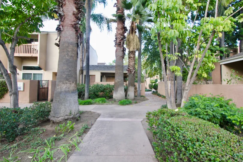A sidewalk path through homes in the Water Gardens neighborhood of Fullerton, California.