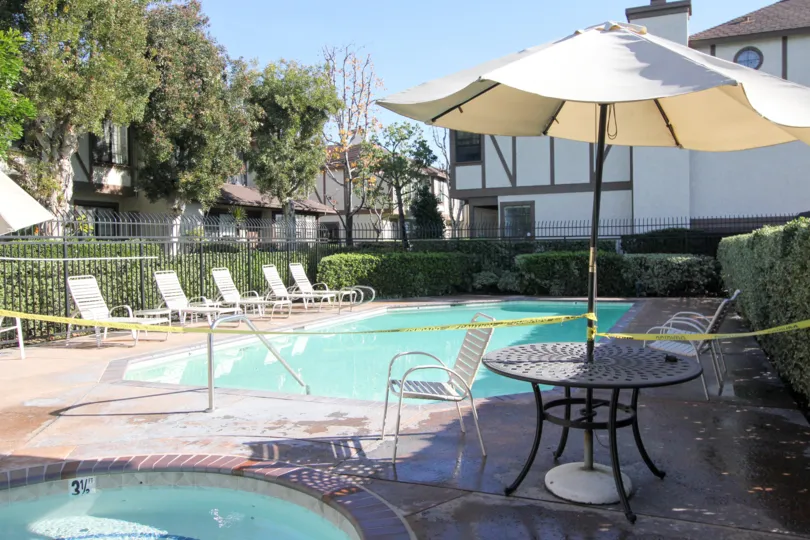 A sunny day in Acacia Park with a swimming pool that's restricted by caution tape.