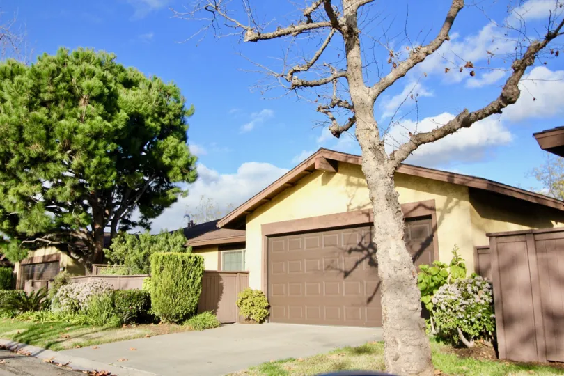 THIS IMAGE SHOWS THE HOME WITH THE SHED WHICH HAS THE PLANTS AND THE TREES NEARBY THE SIDE IS PLACED IN THE CITY OF GARDEN GROVE