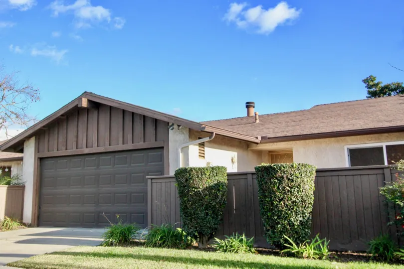A house with a large garage surrounded by garden at Beach terrace community