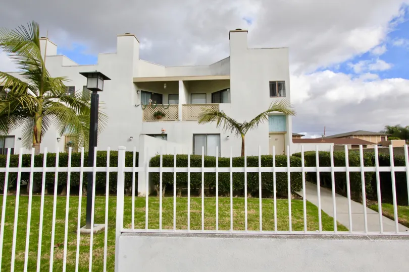 THE SIDEVIEW OF THE VILLA WITH BEAUTIFUL LAWN, PLANTS, TREES, LAMP ARE IN THE GARDEN GROVE CITY