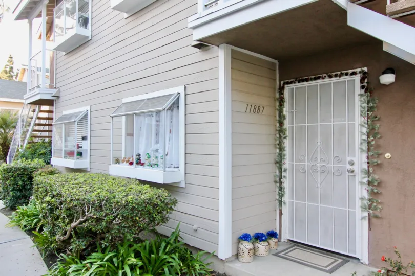 entrance to a house with white doors and white windows and a welcome mat