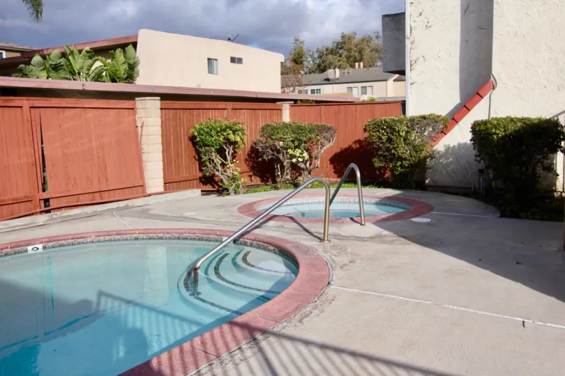 A pool inside the compound near building decorated with trees and plants in Casa Loma Village