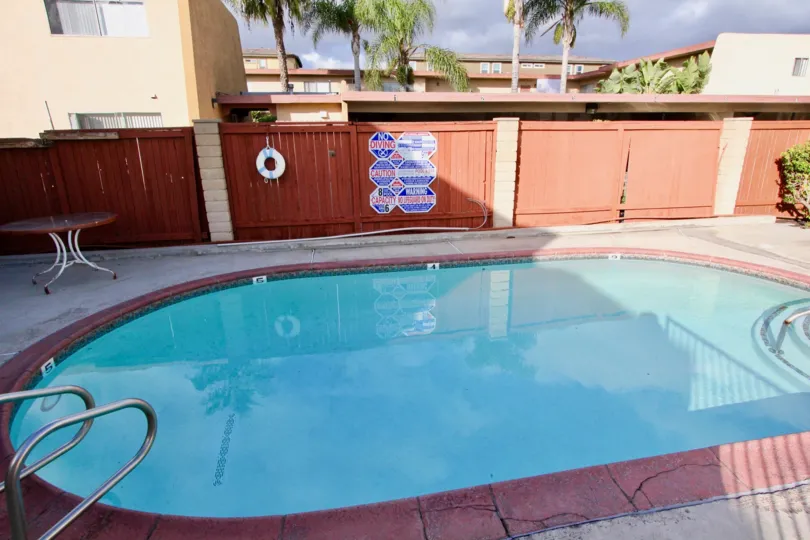 THIS IMAGE REPRESENTS SMALL BEAUTIFUL SWIMMING POOL THAT HAS PURE WATER, AROUNDED THE DOORS, SHOWING THE TREES WHICH IS LOCATED IN THE CITY GARDEN GROVE