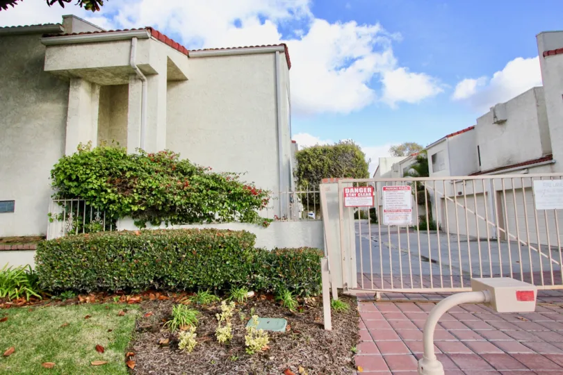 THIS IS THE ENTRANCE WAY TO THE APARTMENTS THAT SHOWS DANGER BOADR ON THE GATE, NEARBY PLANTS ARE PLANTED WHICH IS IN THE CITY OF GARDEN GROVE