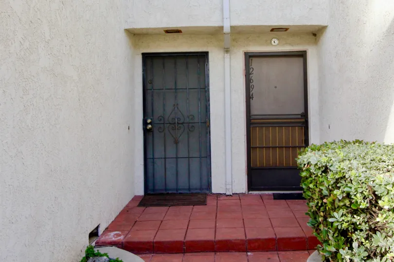 THIS IS THE FRONTWAY TO THE HOME WHICH IS LOCATED IN THE CITY OF GARDEN GROVE THAT LOOKS THE NUMBERS ON THE DOOR AND PLANTS ARE PLANTED