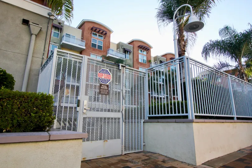 security entrance with a warning sign and fencing protecting the housing inside