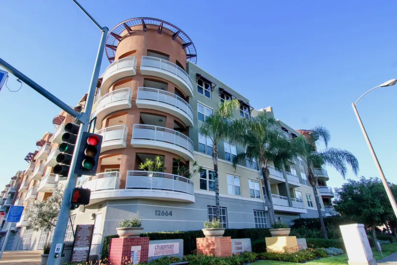 THE 12564 APARTMENT IN THE CHAPMAN COMMONS WITH THE TRAFFIC SIGNAL, PLANTS, LAWN, STREET LIGHT, TREES