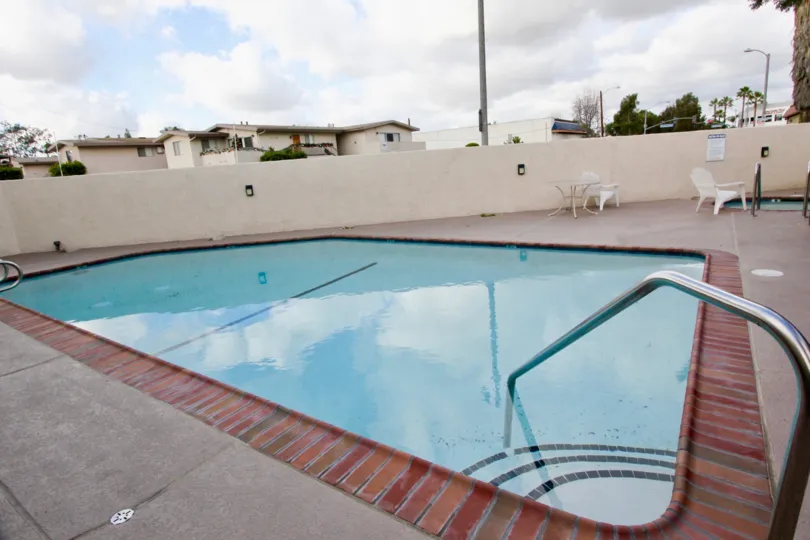 a rectangular pool on a rooftop with a jacuzzi in back