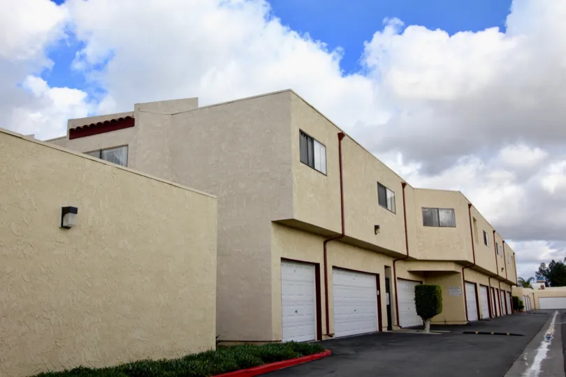 A row of apartments with included garages on a cloudy day in the Garden Creek neighborhood of Garden Grove, California.
