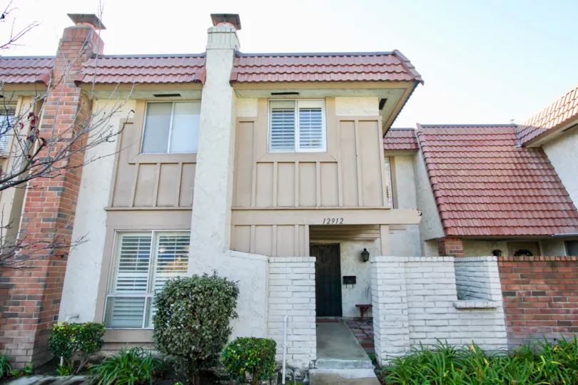 Two Story Home with tile roof and brick walled entrance way at Garden Park in Garden Grove, CA