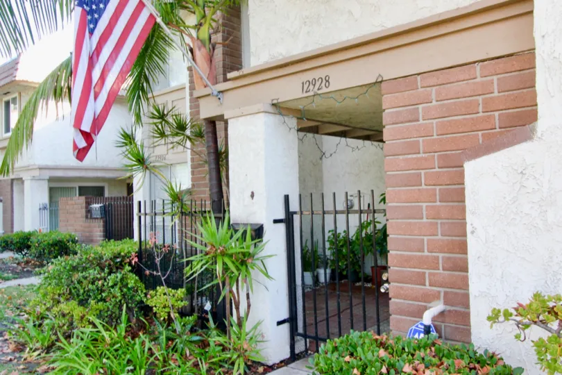 A Flag, Iron Gate and Brick Work at Entrance at Garden Park in Garden Grove, CA