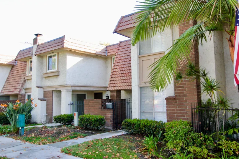 Palm trees and green vegetation accent, the beige opaques of these neighborhood houses. The american flag on the palm tree is an allusion to the ideals of the dreams of this great country.