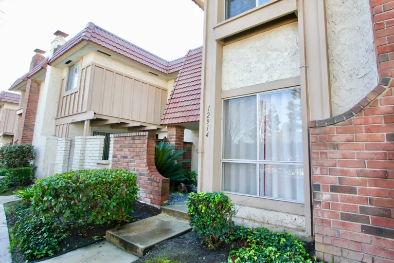 THIS IS THE FRONT VIEW OF THE FLATS THAT HAS THE NUMBER ON THE WALL, PLANTS ARE NEARBY PLANTED WHICH IS IN THE CITY OF GARDEN GROVE