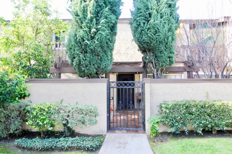THE HOME IN THE GARDEN TERRACE TOWNHOMES WITH THE GATE, LAWN, PLANTS, TREES