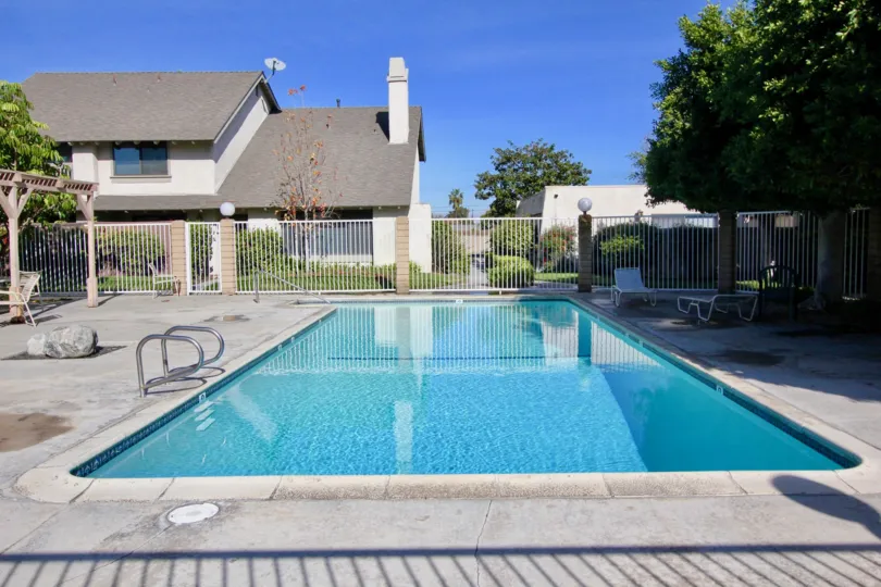 THE HOME IN THE HIDDEN VILLAGE WITH THE SWIMMING POOL, ROCK, TABLES, TREES, DISH ANTENNA