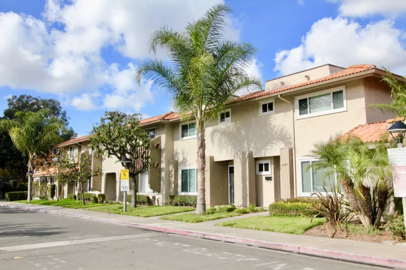 THE HOUSE IN THE LA JOLLA PLAZA WITH THE PLANTS, TREES, LAWN