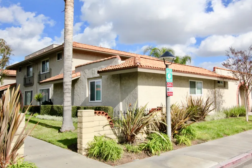 THE HOME IN THE LA JOLLA PLAZA WITH THE PATHWAY, LAWN, PLANTS, TREES