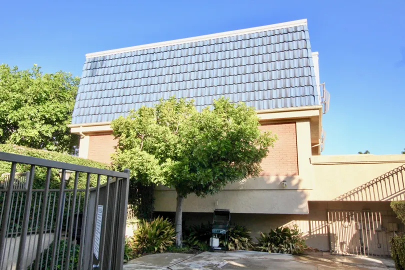 THIS IS THE SIDEVIEW OF THE HOUSE THAT HAS THE PLANTS, TREES, EMPTY SPACE LOCATED IN THE CITY GARDEN GROVE
