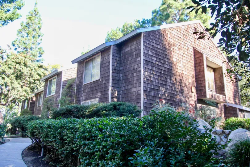 A wood-siding apartment complex with bushes out front at Lake Grove, in Garden Grove, California.