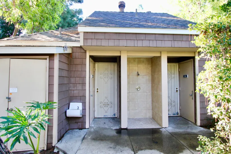THE BUILDING IN THE LAKE GROVE WITH THE PLANTS, TREES, LOCKED DOOR