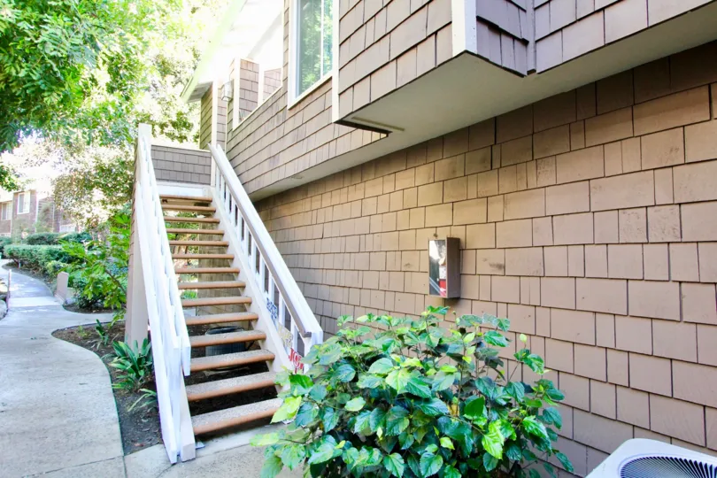 THE BUILDING IN THE LAKE GROVE WITH THE UPSTAIRS, PLANTS, TREES