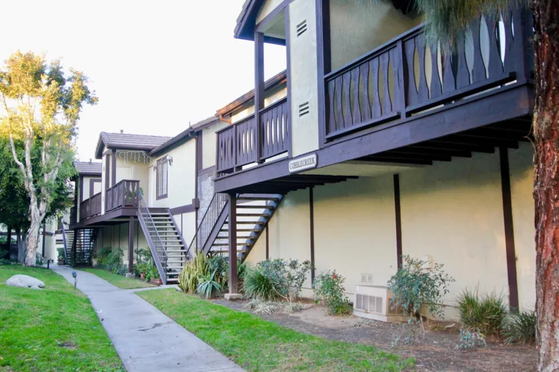 Balcony above landscaping and sidewalk at Les Jardins in Garden Grove, CA