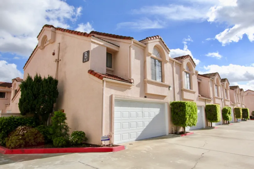 THE SIDE VIEW OF THE FLATS WITH SHED, PLANTS AND MENTION B ON THE WALL ARE THERE IN THE CITY OF GARDEN GROVE