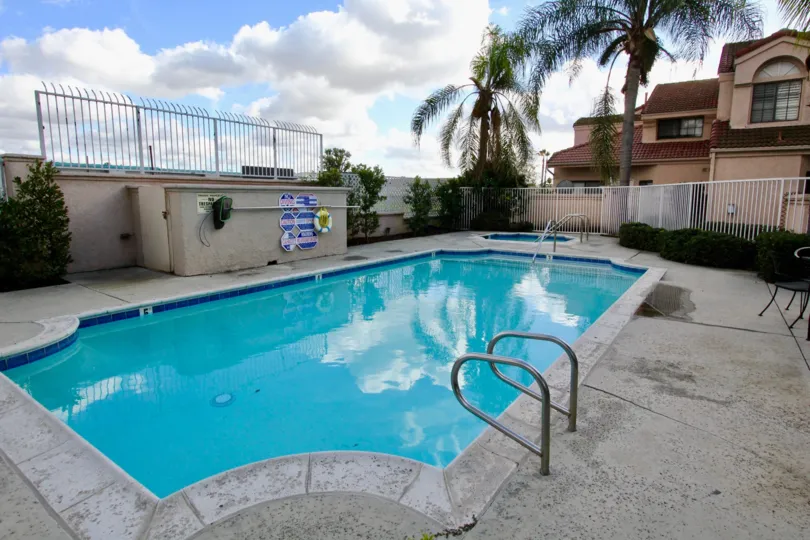 THE HOME IN THE MARTINQUE GARDENS WITH THE SWIMMING POOL, CHAIRS, PLANTS, TREES