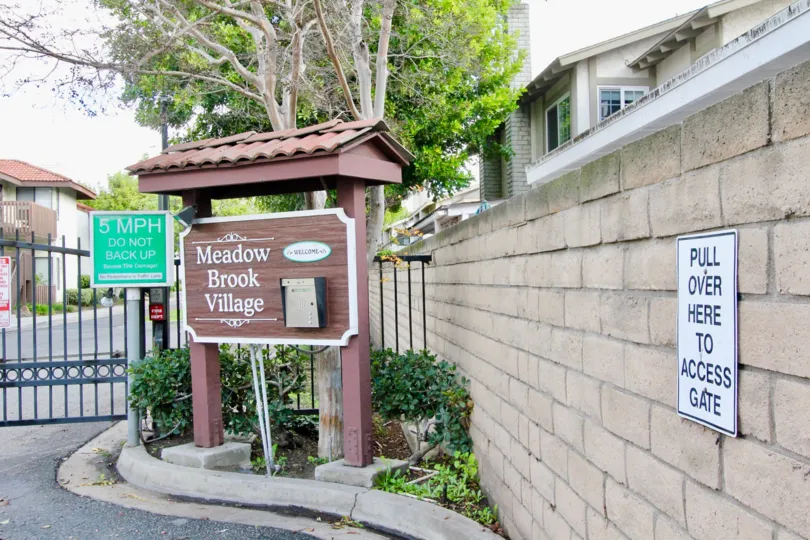 THE HOUSE IN THE MEADOW BROOK VILLAGE WITH THE MEADOW BROOK VILLAGE BOARD