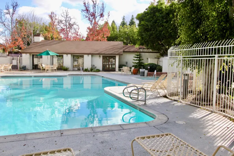 THIS BEAUTIFUL SWIMMING POOL IS IN THE CITY OF GARDEN GROVE THAT THE LOT OF CHAIRS, SHOWS THE LOT OF TREES, NEARBY THE HOME