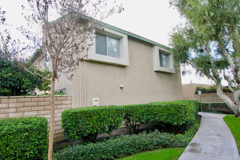 Rear of home with manicures lawn and neatly trimmed hedges at Pacific Gardens in Garden Grove, CA
