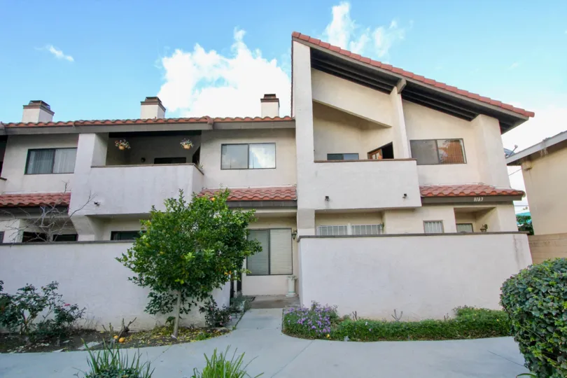 THE HOUSE IN THE PEPPERTREE TOWNHOMES WITH THE BALCONI, FLOWER POTS, TREES