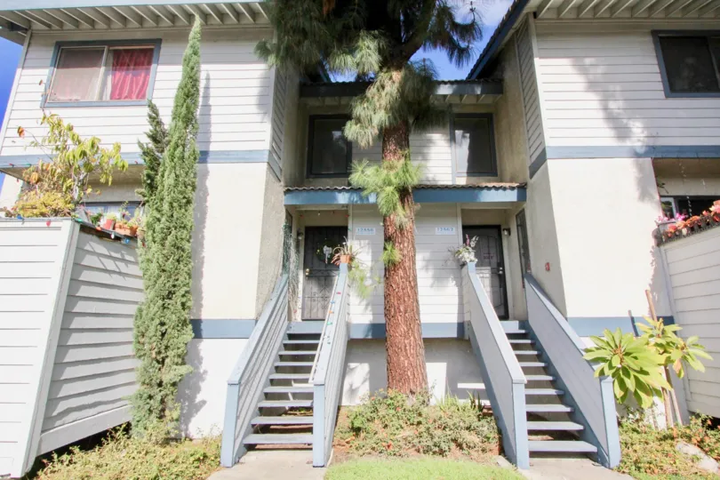 THE FRONT VIEW OF FLAT WITH STEPS, PLANTS, TREES WHICH IS LOCATED IN GARDEN GROVE