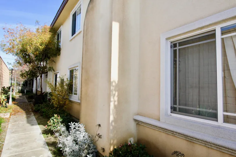 An open home window near a walkway inside Pine Villas in Garden Grove CA