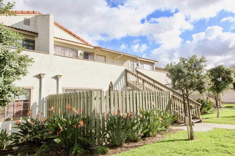 A two story residence with a fence-lined garden at Spring Garden Villas, in Garden Grove, California.