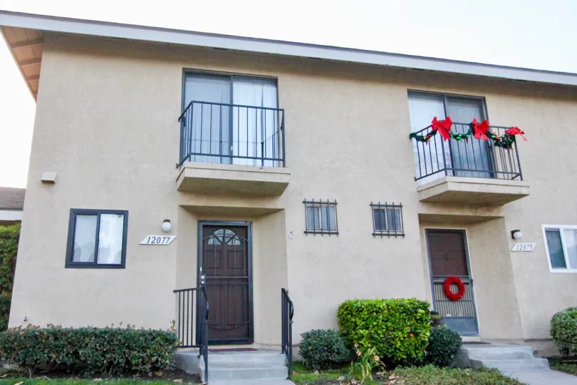 residencies with second floor balconies with one of them decorated for christmas
