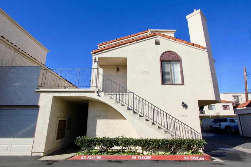 THE FRONTVIEW OF HOME WITH STEPS, CAR, PLANTS UNDER THE STEPS, ROADWAY ARE SHOWN IN THE CITY OF GARDEN GROVE